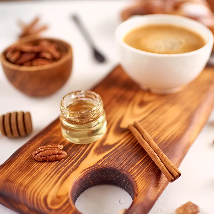 a wooden board with a cup of coffee and a jar of honey